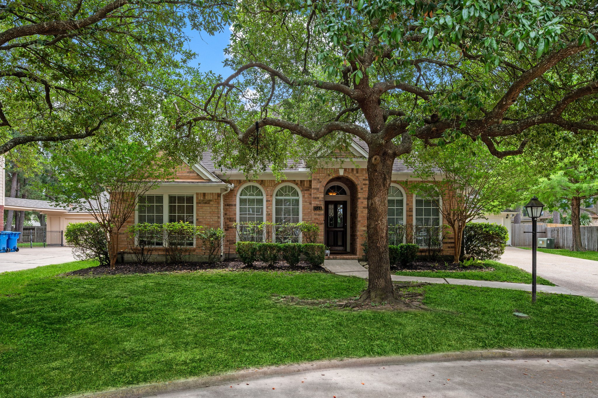 7514 Tumbling Road Humble, TX 77346 - Photo 27 of 28 a front view of a house with a garden and trees