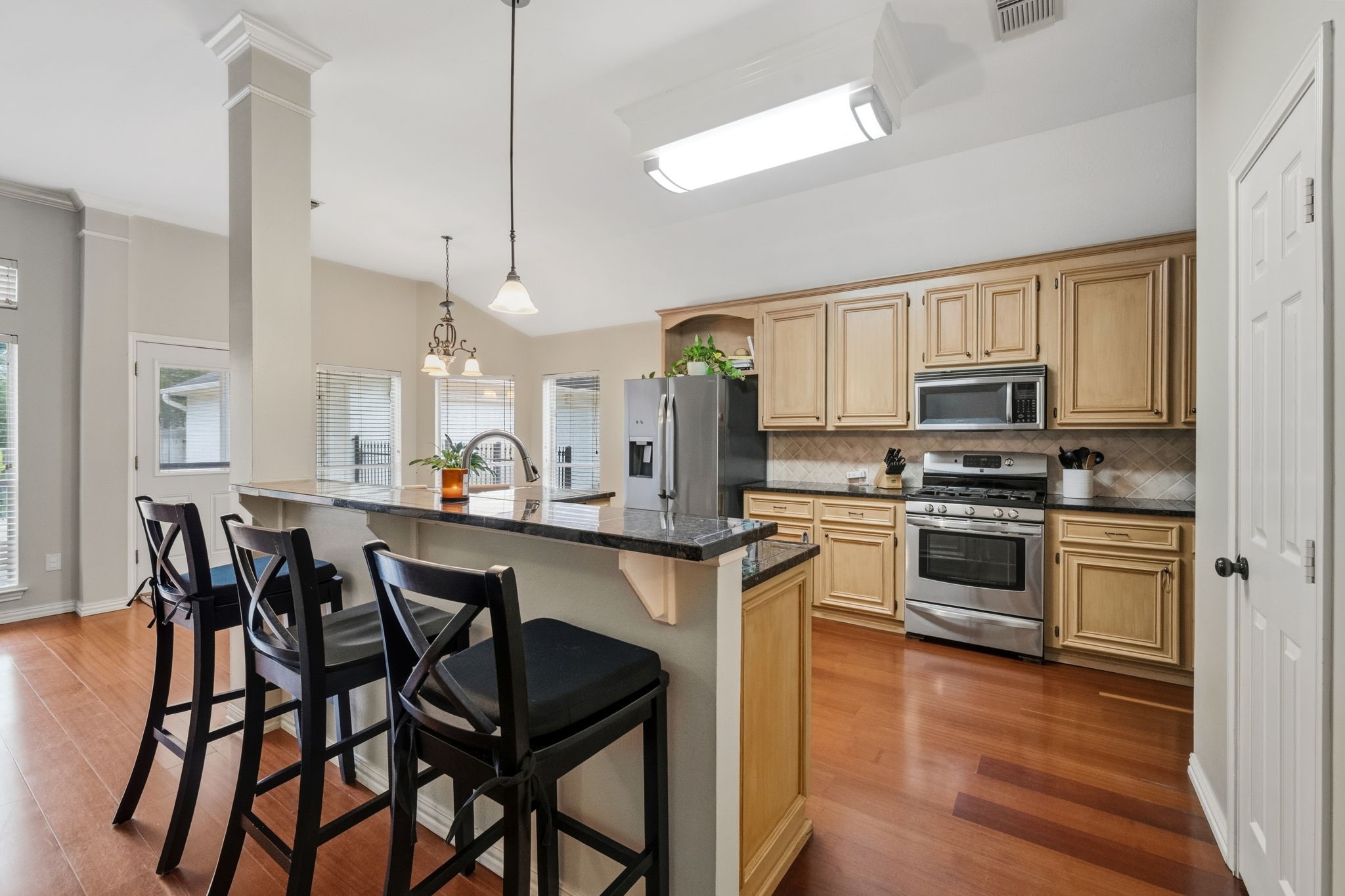 7514 Tumbling Road Humble, TX 77346 - Photo 9 of 28 a kitchen with stainless steel appliances granite countertop white cabinets a sink a stove a dining table and chairs