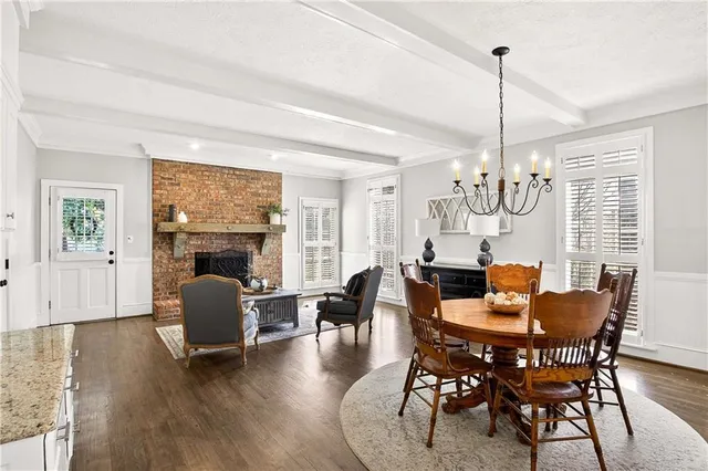 a dining room with furniture a chandelier and wooden floor