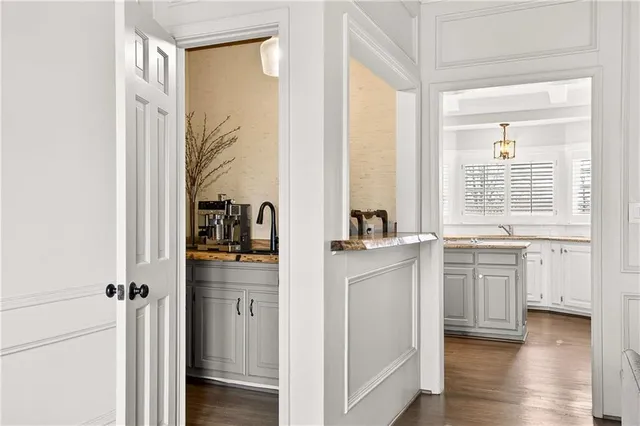 a room with granite countertop white cabinets and wooden floor