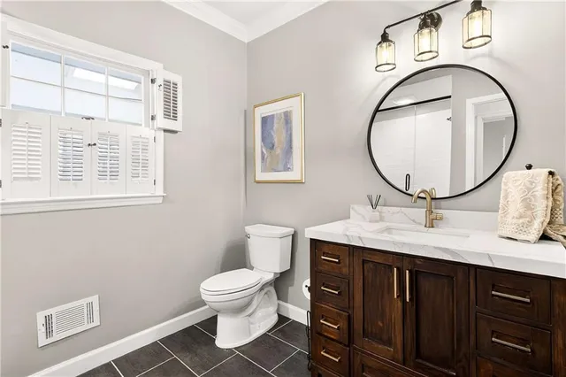 a bathroom with a granite countertop sink a toilet and a mirror