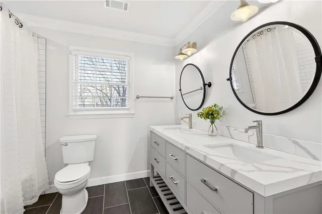 a bathroom with a granite countertop toilet a sink and a mirror