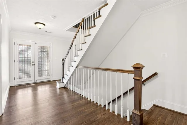 a view of staircase with wooden floor and white walls