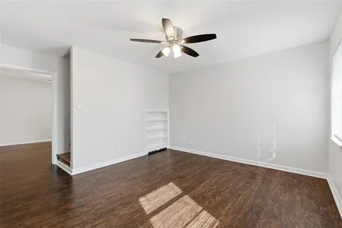 a view of a kitchen with white cabinets and wooden floor