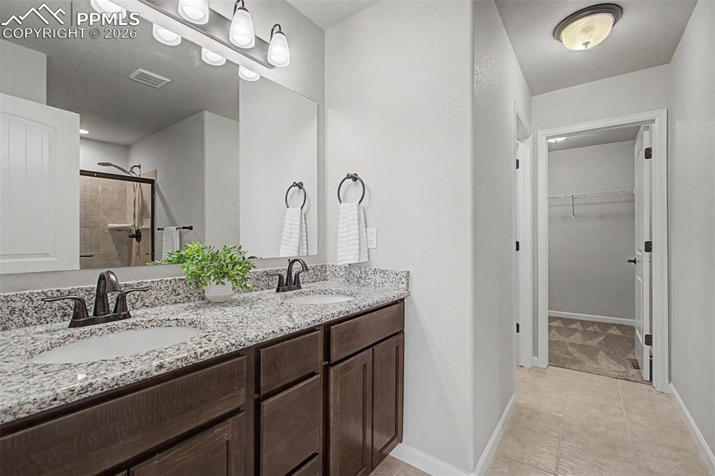 4467 Hessite Loop Colorado Springs, CO 80938 - Photo 20 of 37 a bathroom with a granite countertop sink and a mirror