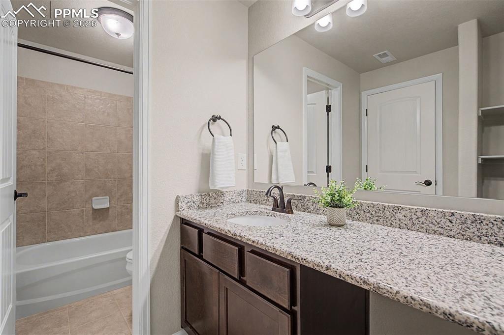 4467 Hessite Loop Colorado Springs, CO 80938 - Photo 31 of 37 a bathroom with a granite countertop sink and a mirror