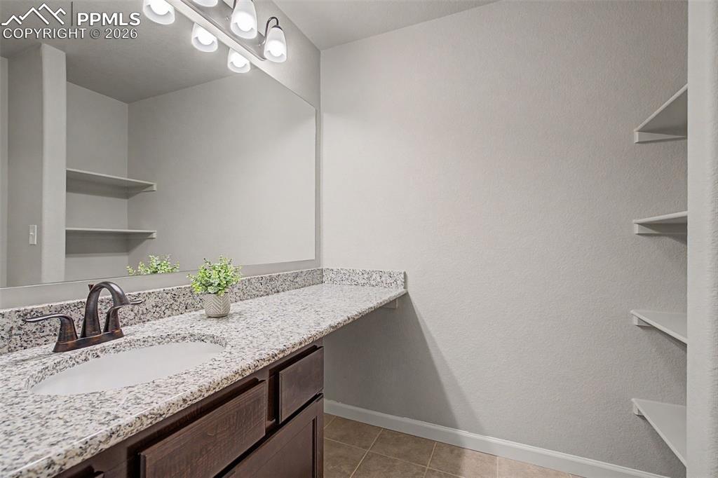 4467 Hessite Loop Colorado Springs, CO 80938 - Photo 32 of 37 a bathroom with a granite countertop sink and a mirror