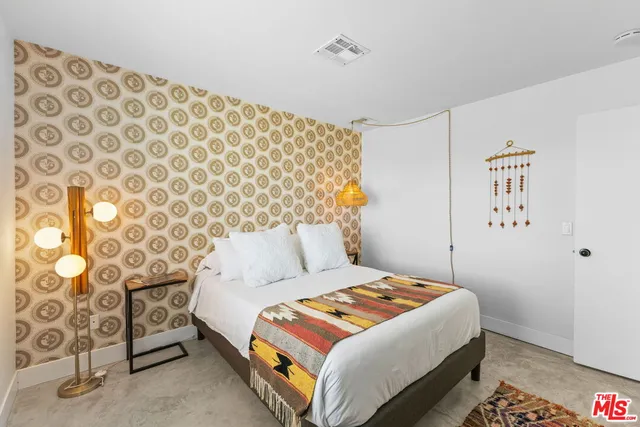 a bedroom with a bed lamp and a window