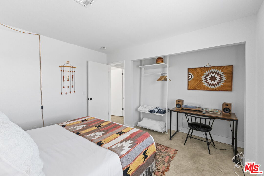 4789 Avenida Del Sol Joshua Tree, CA 92252 - Photo 17 of 37 a bedroom with a bed and a table in it