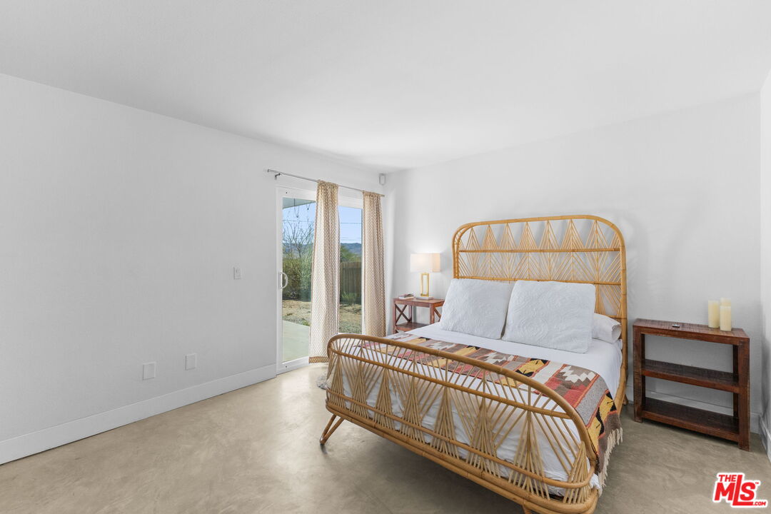 4789 Avenida Del Sol Joshua Tree, CA 92252 - Photo 18 of 37 a bedroom with a bed and a window