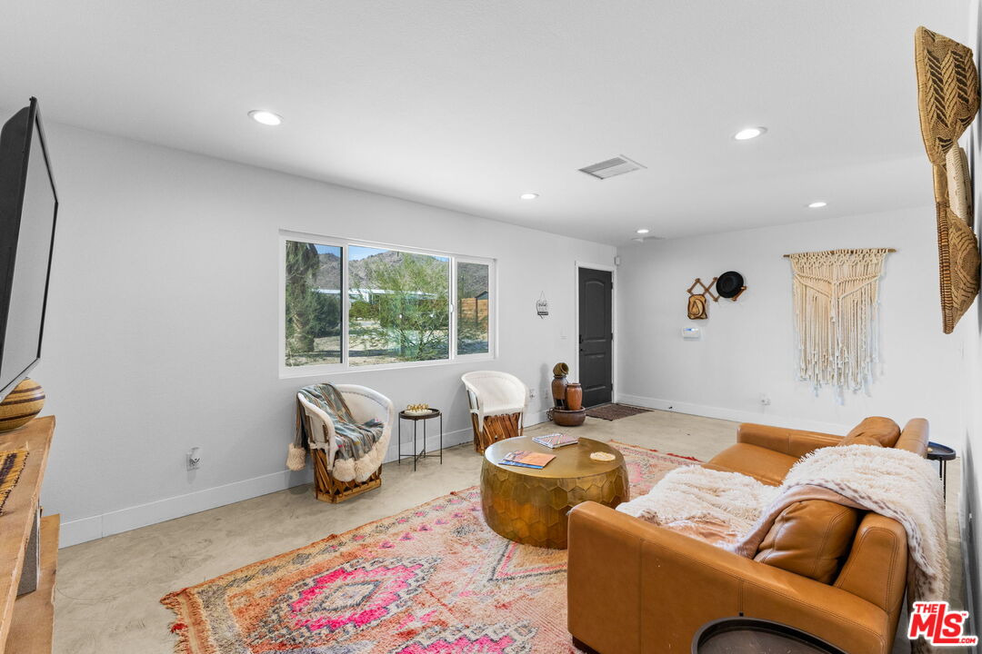 4789 Avenida Del Sol Joshua Tree, CA 92252 - Photo 2 of 37 a living room with furniture and a flat screen tv