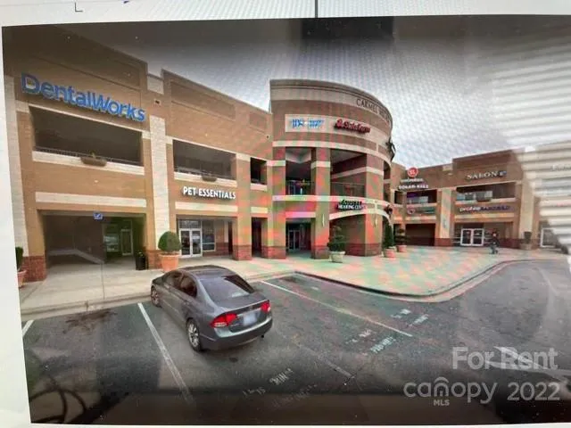 a front view of a building with cars