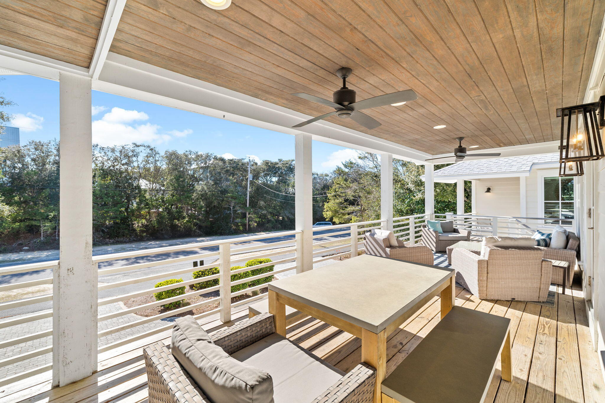 6312 West County Highway 30A Santa Rosa Beach, FL 32459 - Photo 13 of 58 a view of a patio with a table chairs and a floor to ceiling window