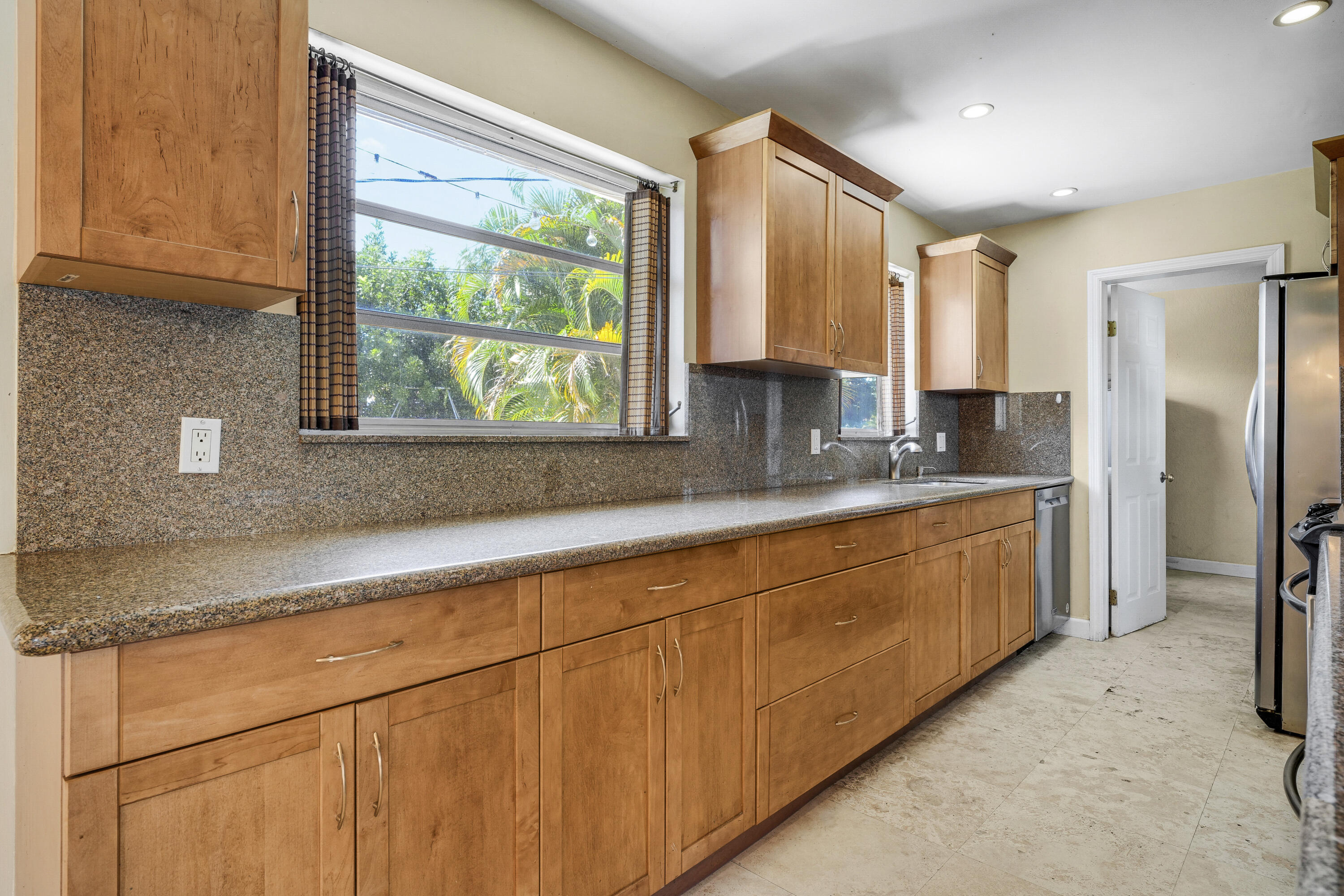 20 Willow Road Tequesta, FL 33469 - Photo 21 of 43 a kitchen with stainless steel appliances granite countertop a sink a refrigerator and a granite counter tops