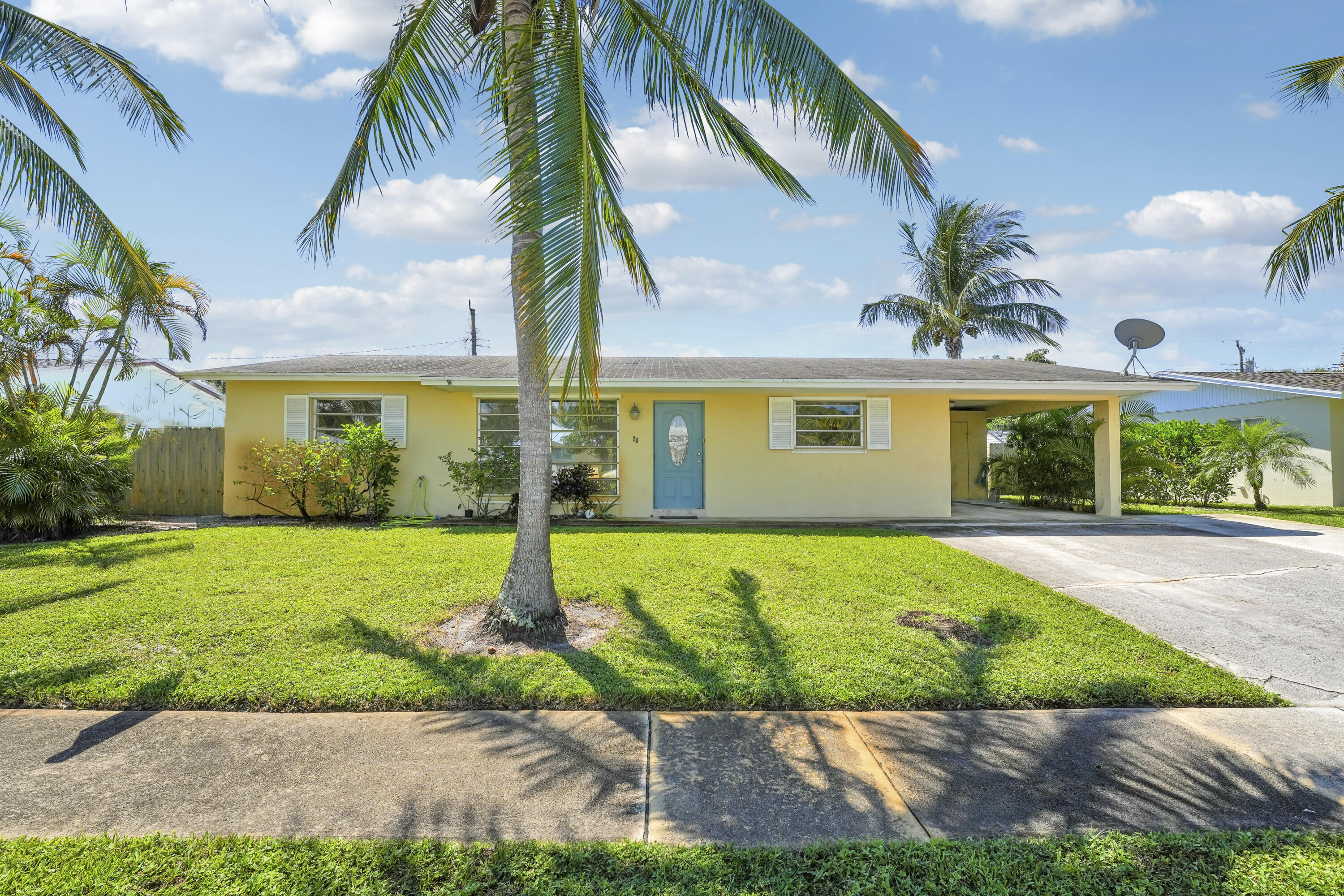 20 Willow Road Tequesta, FL 33469 - Photo 5 of 43 a front view of a house with a garden and yard