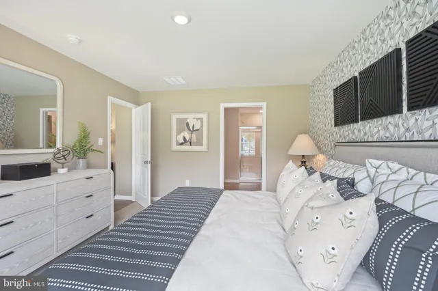 a bedroom with a bed and a lamp on dresser