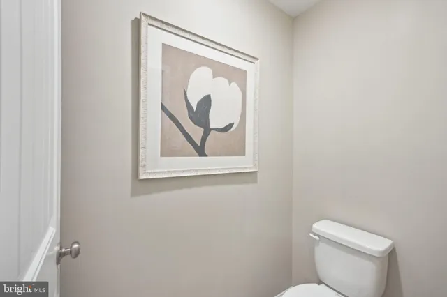 a white toilet sitting next to a white wall