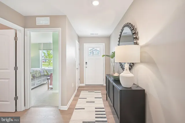 a walk in closet with wooden floor