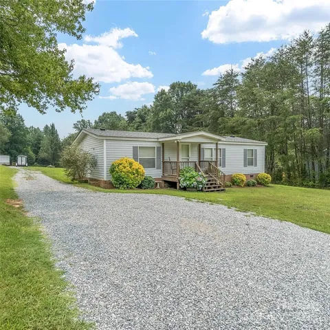 a view of house with a yard and potted plants