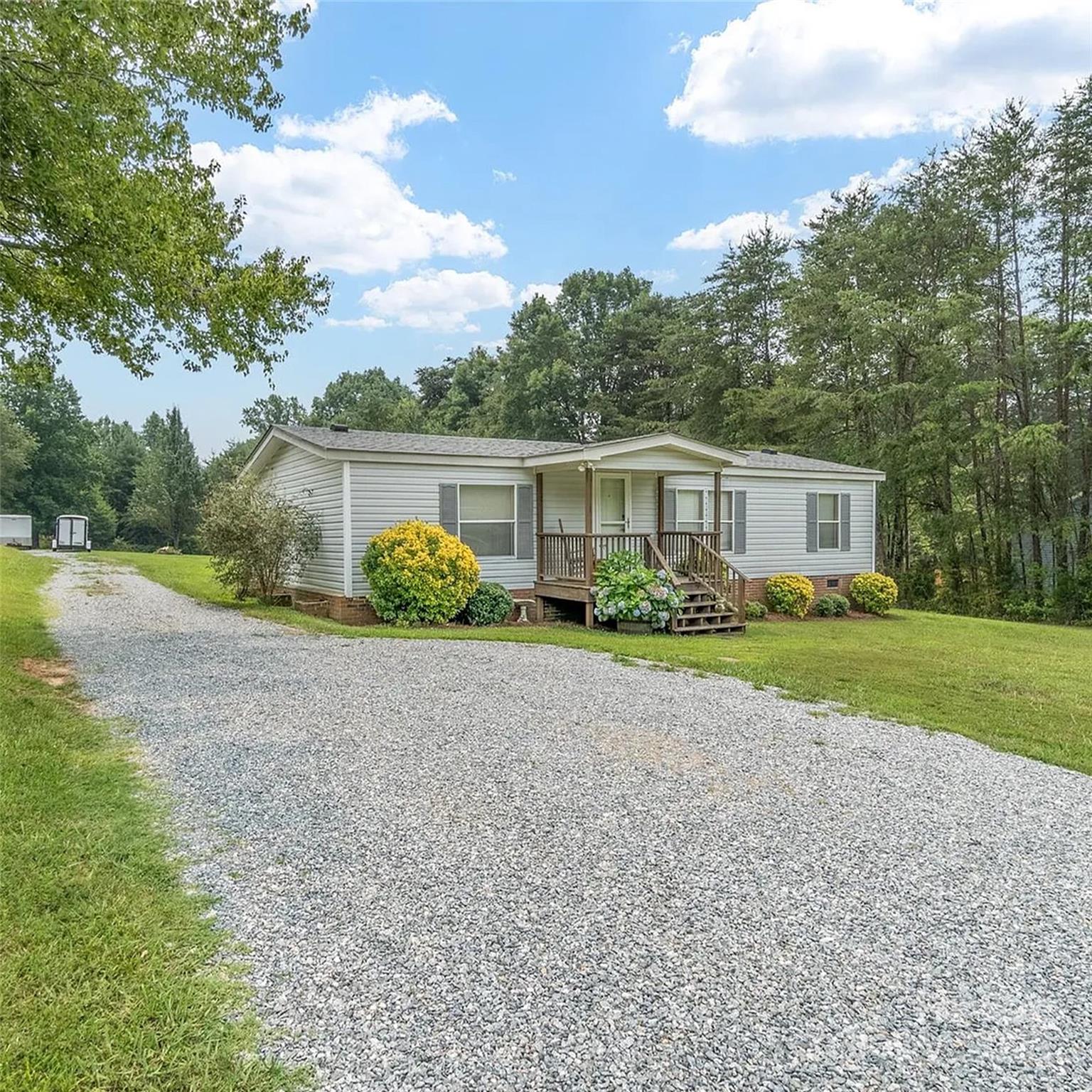 a view of house with a yard and potted plants