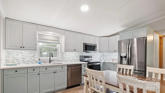 a kitchen with stainless steel appliances a sink stove refrigerator and cabinets