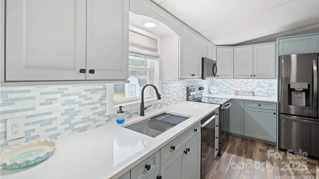 a kitchen with stainless steel appliances a sink a stove and a refrigerator