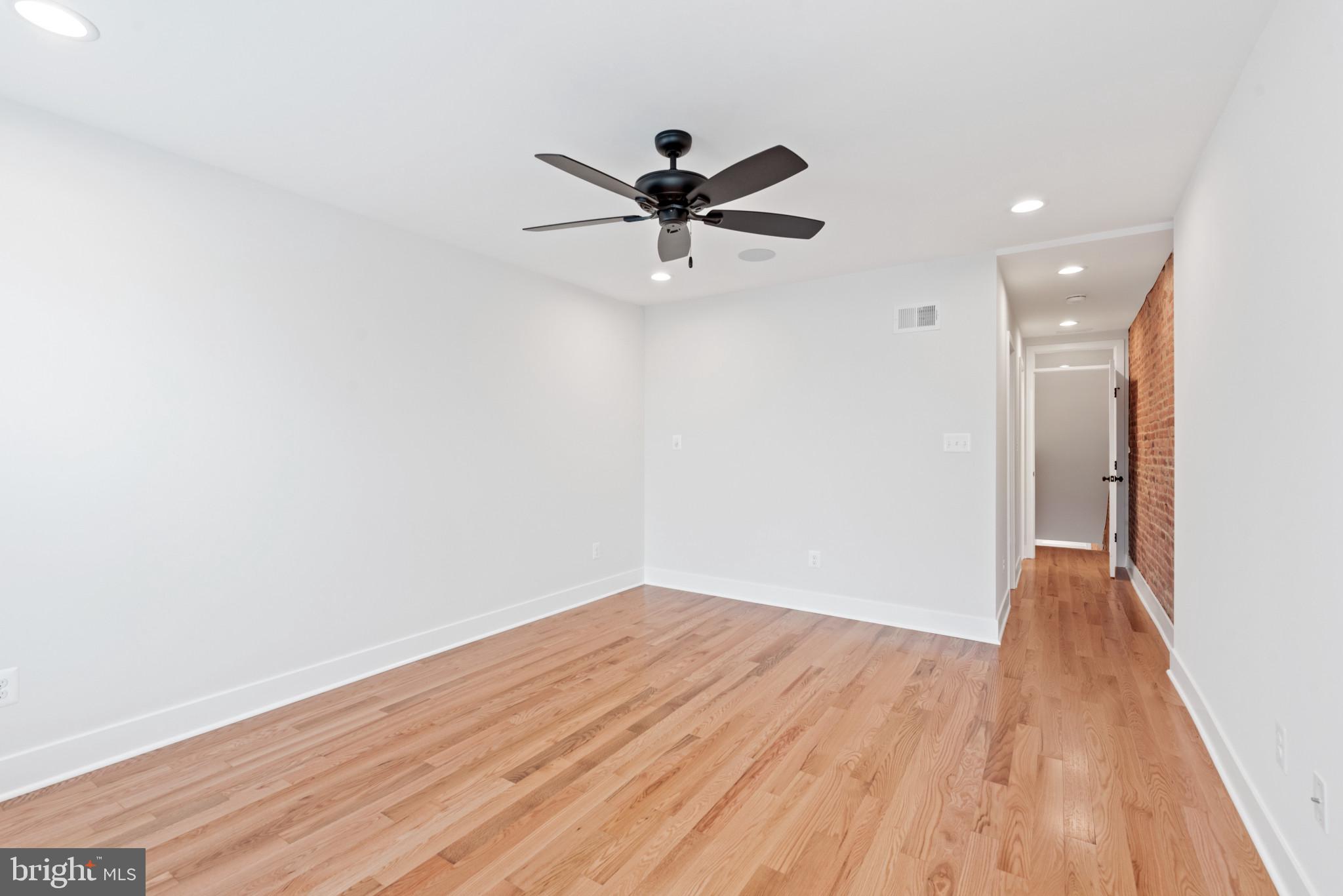 1434 Marshall Street Baltimore, MD 21230 - Photo 19 of 40 a view of a big room with wooden floor a ceiling fan and closet