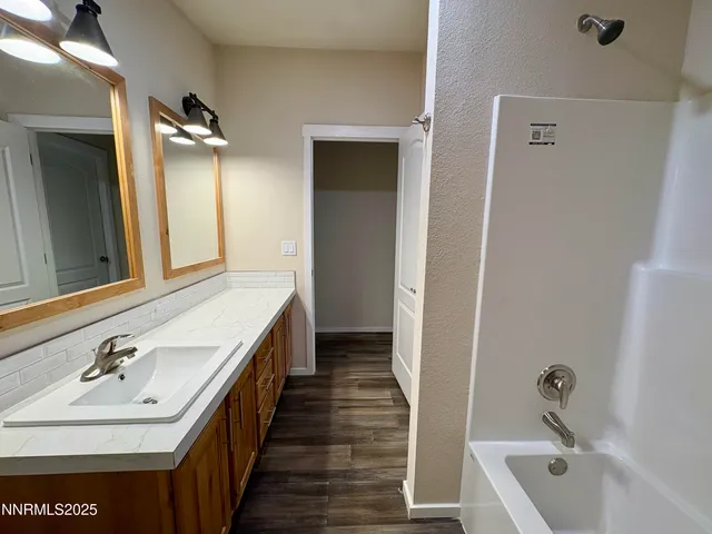 a bathroom with a tub sink and mirror