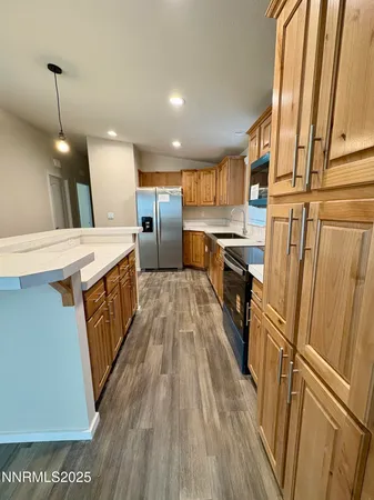 a kitchen with a sink a refrigerator a window and wooden floor
