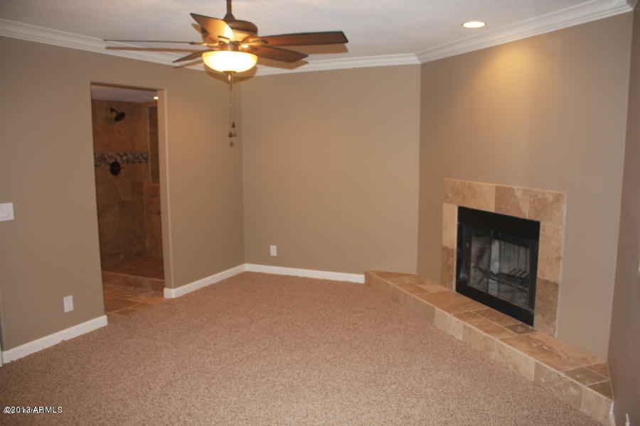 1522 West Del Rio Street Chandler, AZ 85224 - Photo 7 of 11 a view of an empty room with chandelier fan and fire place