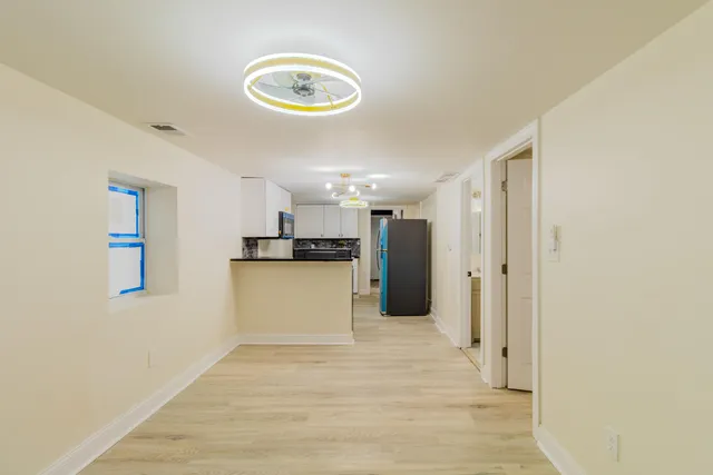 a view of a kitchen with a sink and a refrigerator