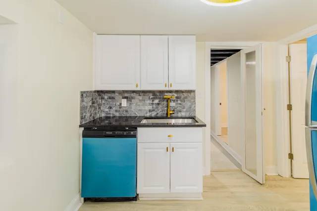 a kitchen with granite countertop a refrigerator stove and sink