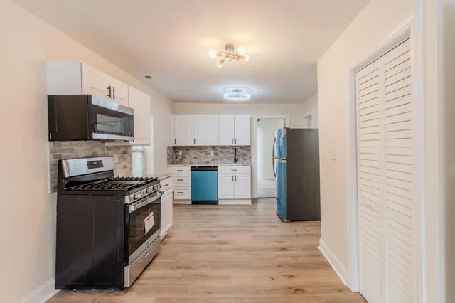 a view of a kitchen with a sink and a refrigerator