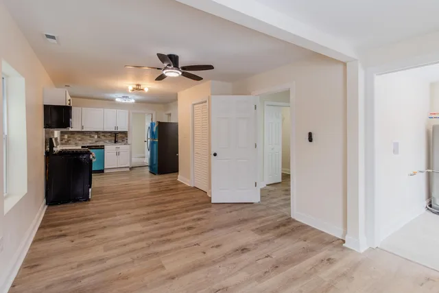 a kitchen with granite countertop cabinets stainless steel appliances and a wooden floor