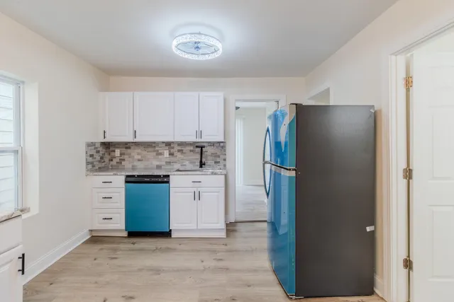 a kitchen with stainless steel appliances granite countertop a stove top oven a refrigerator and a microwave