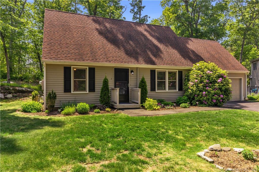 a front view of a house with a yard and plants