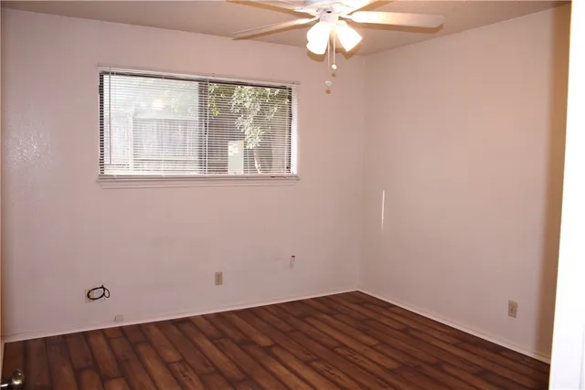 an empty room with a window and wooden floor