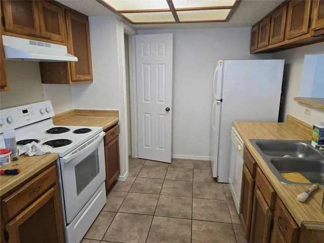 a kitchen with a stove top oven and cabinets