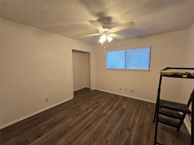 a view of a room with wooden floor and a ceiling fan
