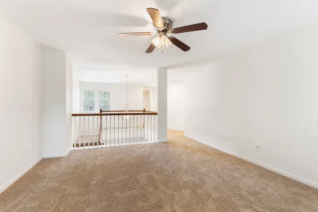 a view of a livingroom with a ceiling fan and window