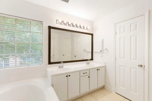 a bathroom with a double vanity sink a mirror and a shower