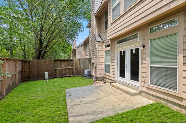 a view of a backyard with a fence and trees
