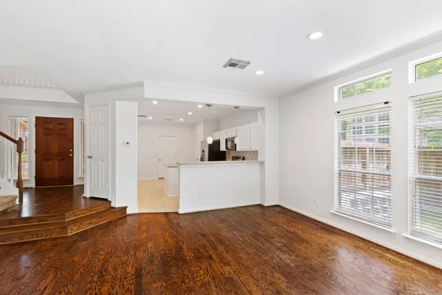a view of a kitchen with wooden floor and a window