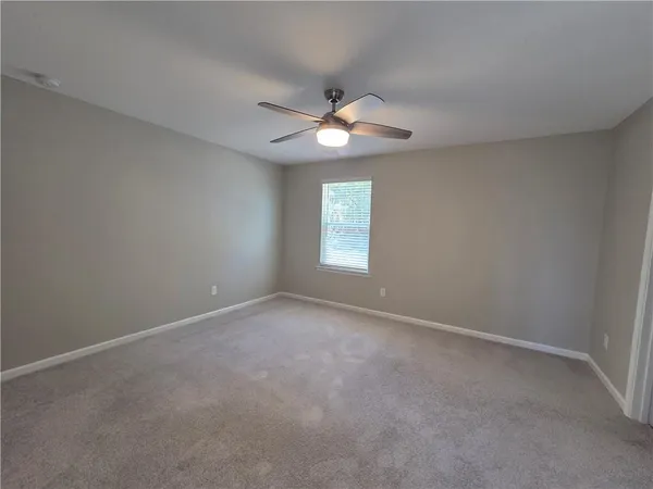 an empty room with a window and a ceiling fan