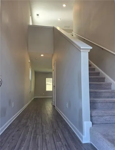 a view of hallway with stairs and wooden floor