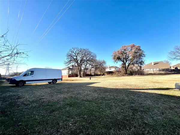a view of yard with swimming pool and trees in the background