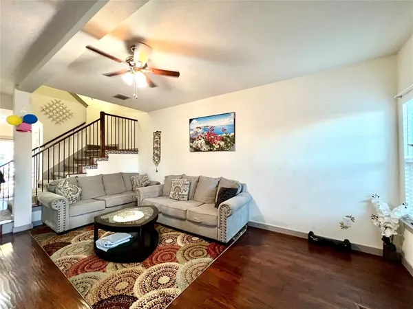 a living room with furniture and wooden floor