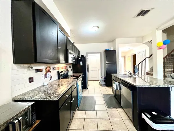 a kitchen with a sink a counter top space and stainless steel appliances