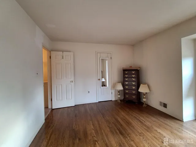 an empty room with wooden floor and closet
