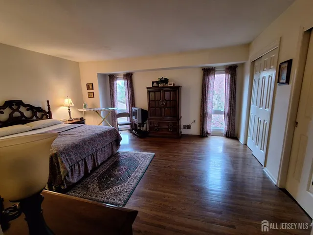a bedroom with bed and wooden floor
